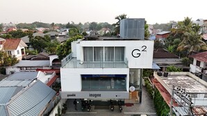 Ein modernes Gebäude mit einem Schild, auf dem im Erdgeschoss „G2“ und „imagine“ stehen.