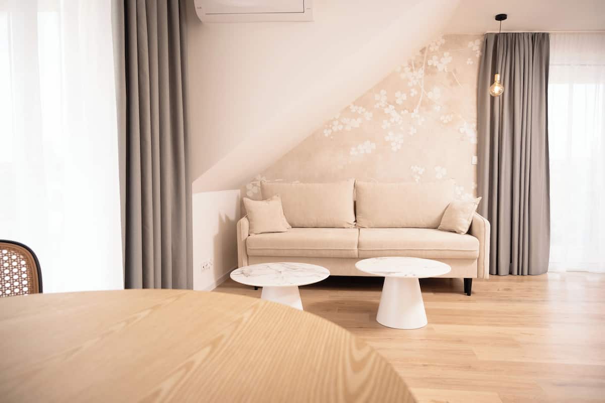 Ein modernes Wohnzimmer mit einer Couch, zwei Couchtischen und einem Esstisch.