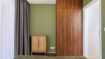 Una habitación con una cama, un armario de madera, un mueble y una puerta.