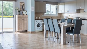 Une cuisine moderne avec un coin repas, un lave-linge et une grande fenêtre.