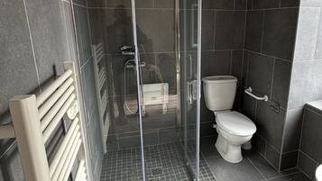 Een douche, een haardroger, handdoeken, toiletpapier