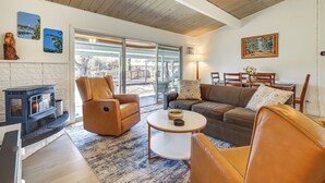 Una sala de estar con chimenea, sillones de cuero, un sofá y un comedor con mesa y sillas.