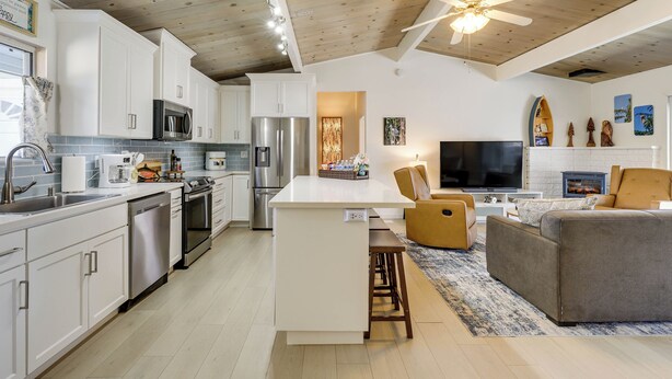 Una cocina moderna con armarios blancos, electrodomésticos de acero inoxidable y una isla central.