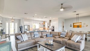 A spacious living room with a sectional sofa, a coffee table, and a kitchen in the background. - Poolside Paradise & Boat Dock! Haven on Lake Clay (Lake Placid)