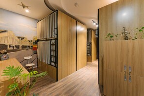 A modern interior with wooden paneling, a mural of a cityscape, and a plant in the foreground. - Hanoi Silver Hostel (Hanoi)