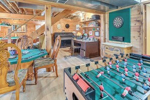 Una habitación acogedora con mesa de fútbol de mesa, dardos y un piano.