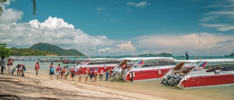 A beach with boats and people.
