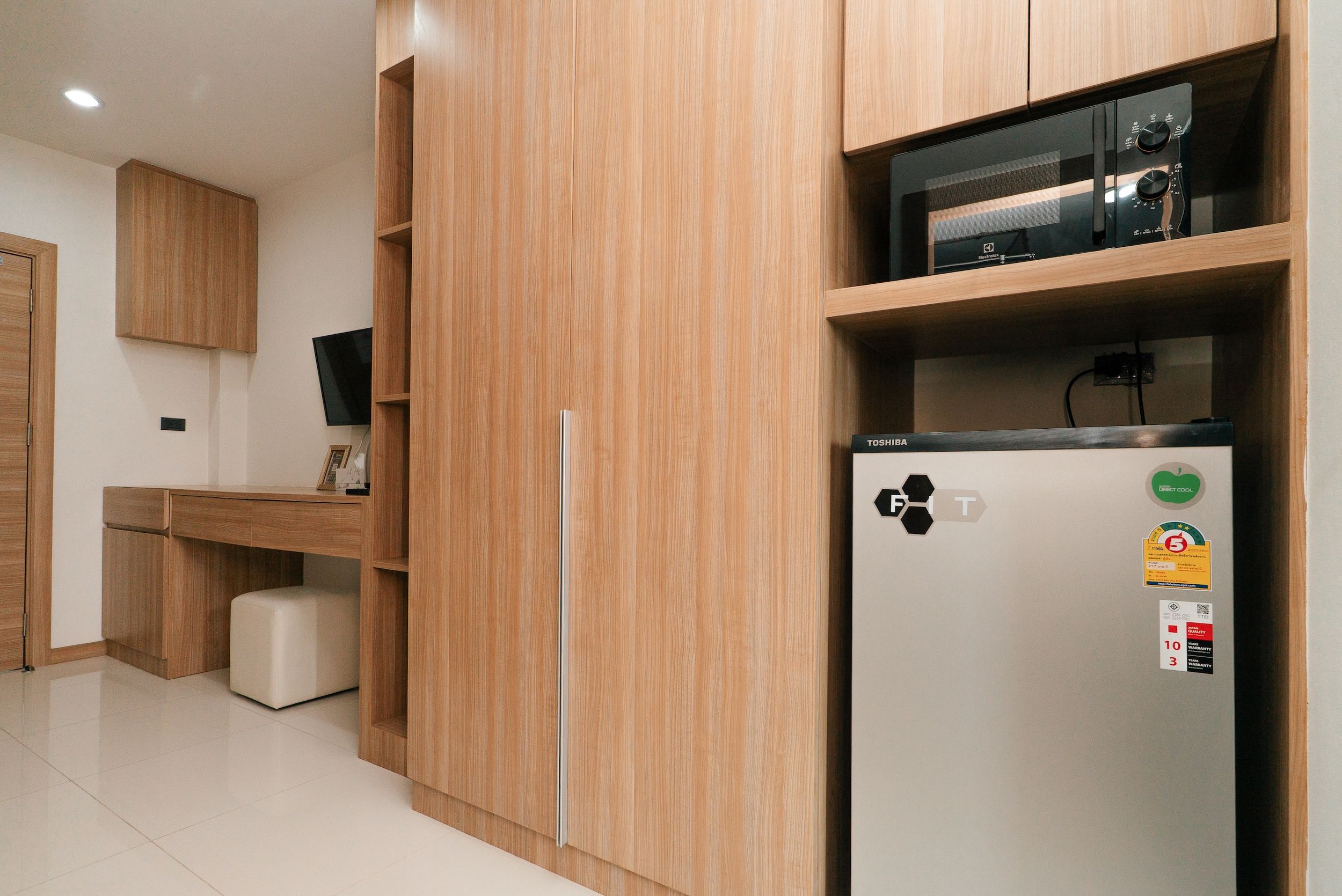 Una kitchenette equipada con refrigerador, microondas y una pequeña encimera.