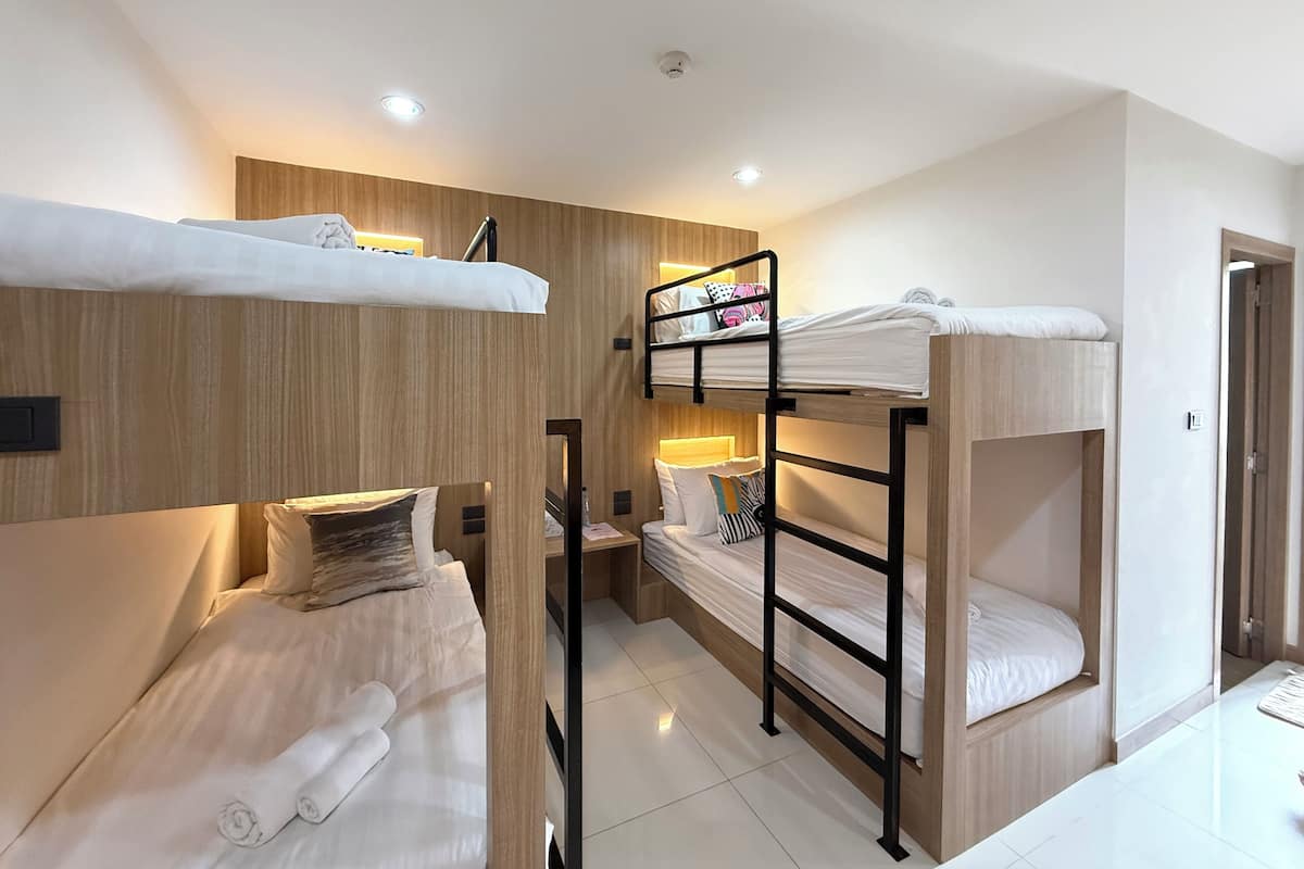 A room with bunk beds, a desk, and a chair.