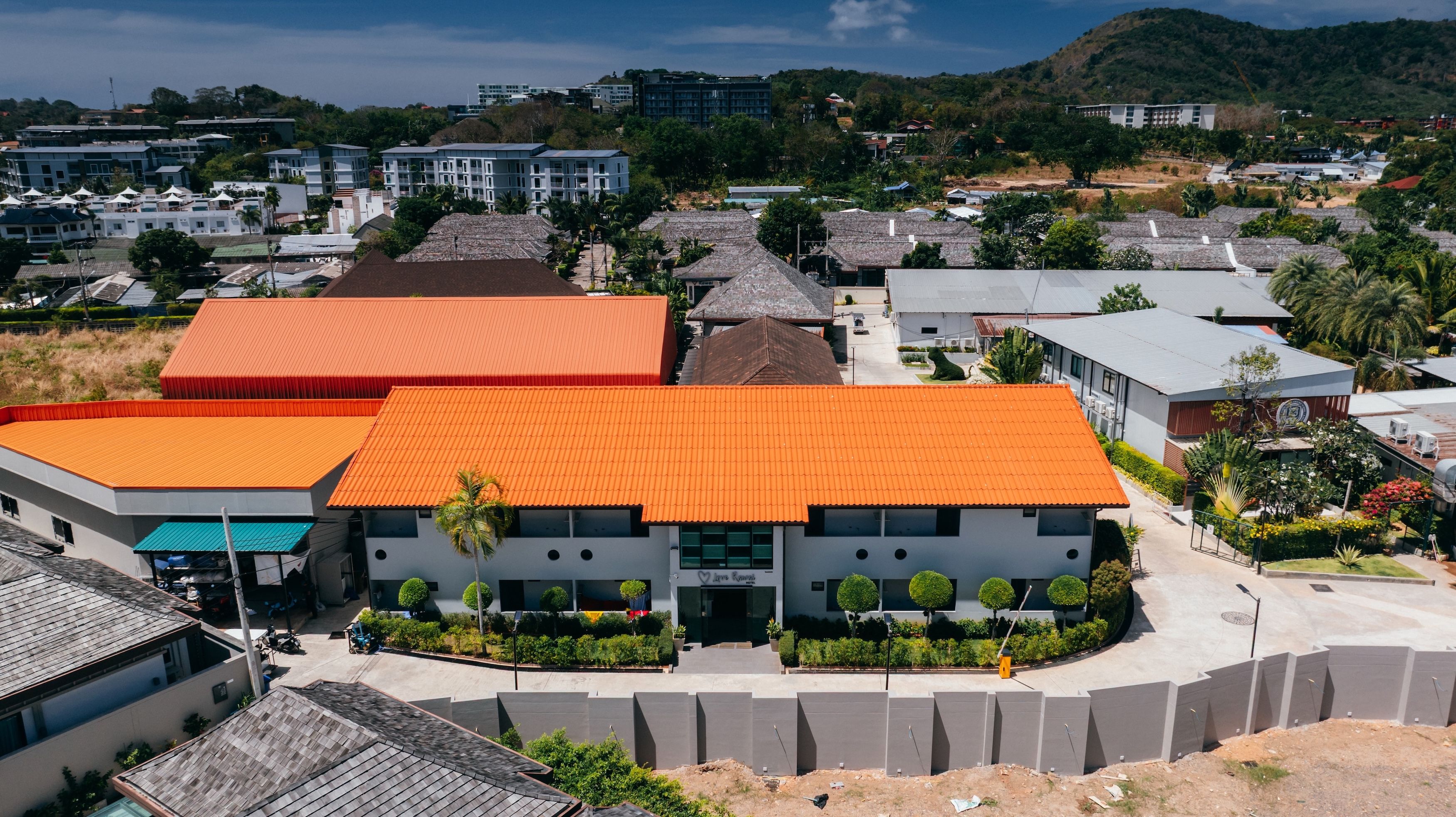 Useita kerroksia sisältävä rakennus, jonka katto on tasainen ja joka on ympäröity viheralueilla ja muilla rakennuksilla.