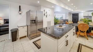 A modern kitchen with white cabinetry, stainless steel appliances, and a central island. - Pool Table + Private Porch: Peaceful Apt in Belle (Belle)