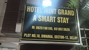 Naamplaatje voor Hotel Mint Grand, dat dit een smart stay hotel is, gelegen op perceelnummer 18, Dwarka, Sector-12, Delhi.