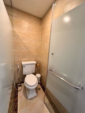 A small bathroom with a toilet, bidet, and a glass shower enclosure. - GSR-Espana condo  (Pattaya)