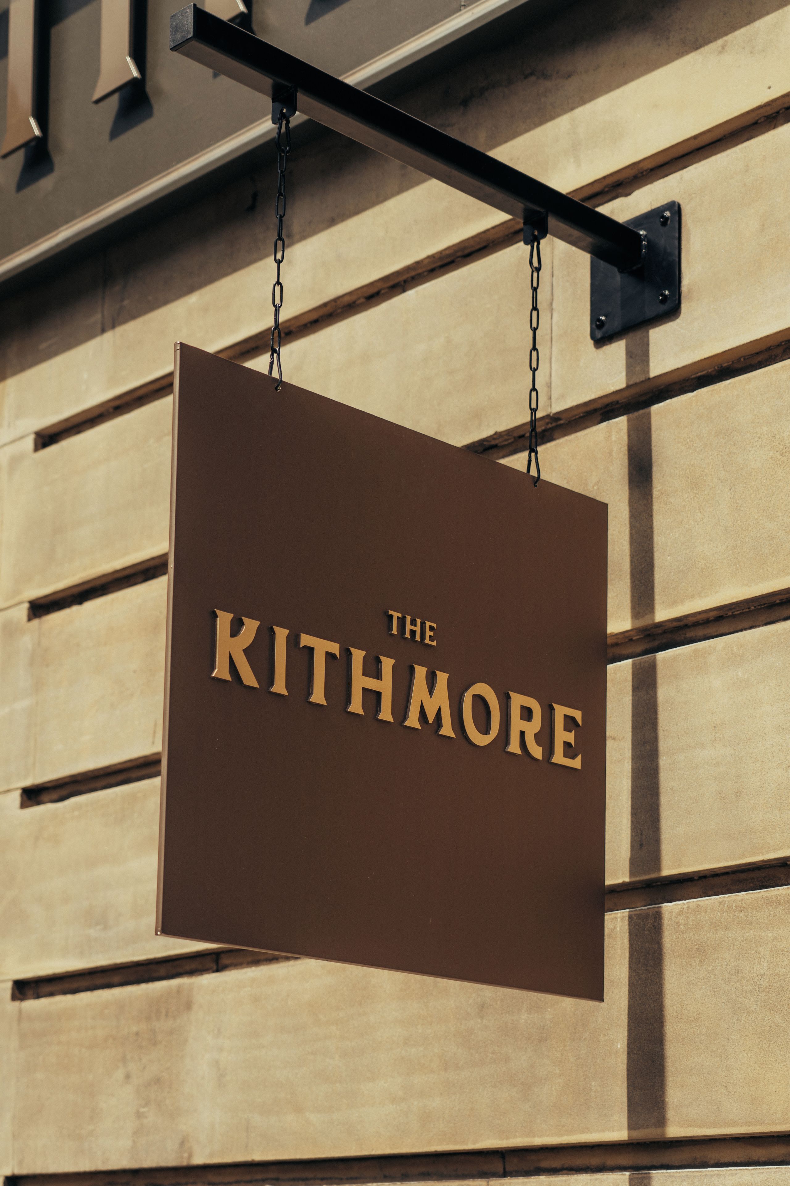 A hanging sign with the name 'The Kithmore' on a building facade.