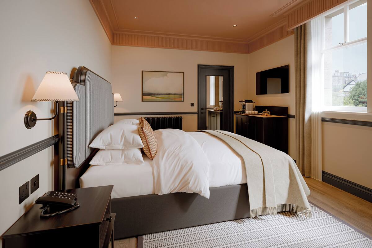 A hotel room with a bed, bedside table with a telephone, a lamp, a painting on the wall, a mirror, and a window with a view.