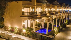 A hotel with multiple balconies, outdoor seating areas, and a pool. - Amruthan Bagh Resort  (Udaipur)