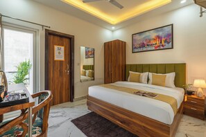 Un dormitorio con cama, escritorio, silla, armario y un cuadro en la pared.