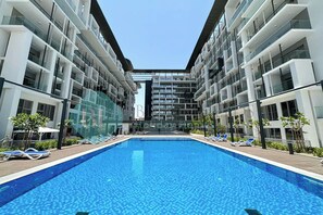 A modern hotel with a central swimming pool, multiple balconies, and a clear sky. - -Bloomfields Premium STU in Oasis Mas (Abu Dhabi)