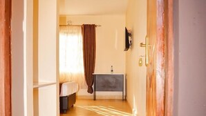 A hallway leading to a bathroom with a sink and a mirror. - Mzedu Springs Hotel Mwatate (Taita Hills)