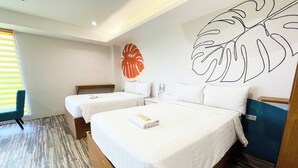 Una camera d'albergo con due letti, un grande murale e un pavimento in legno.