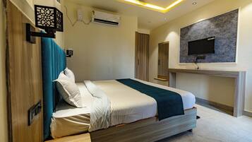 A modern bedroom with a bed, a mounted TV, and an air conditioning unit.