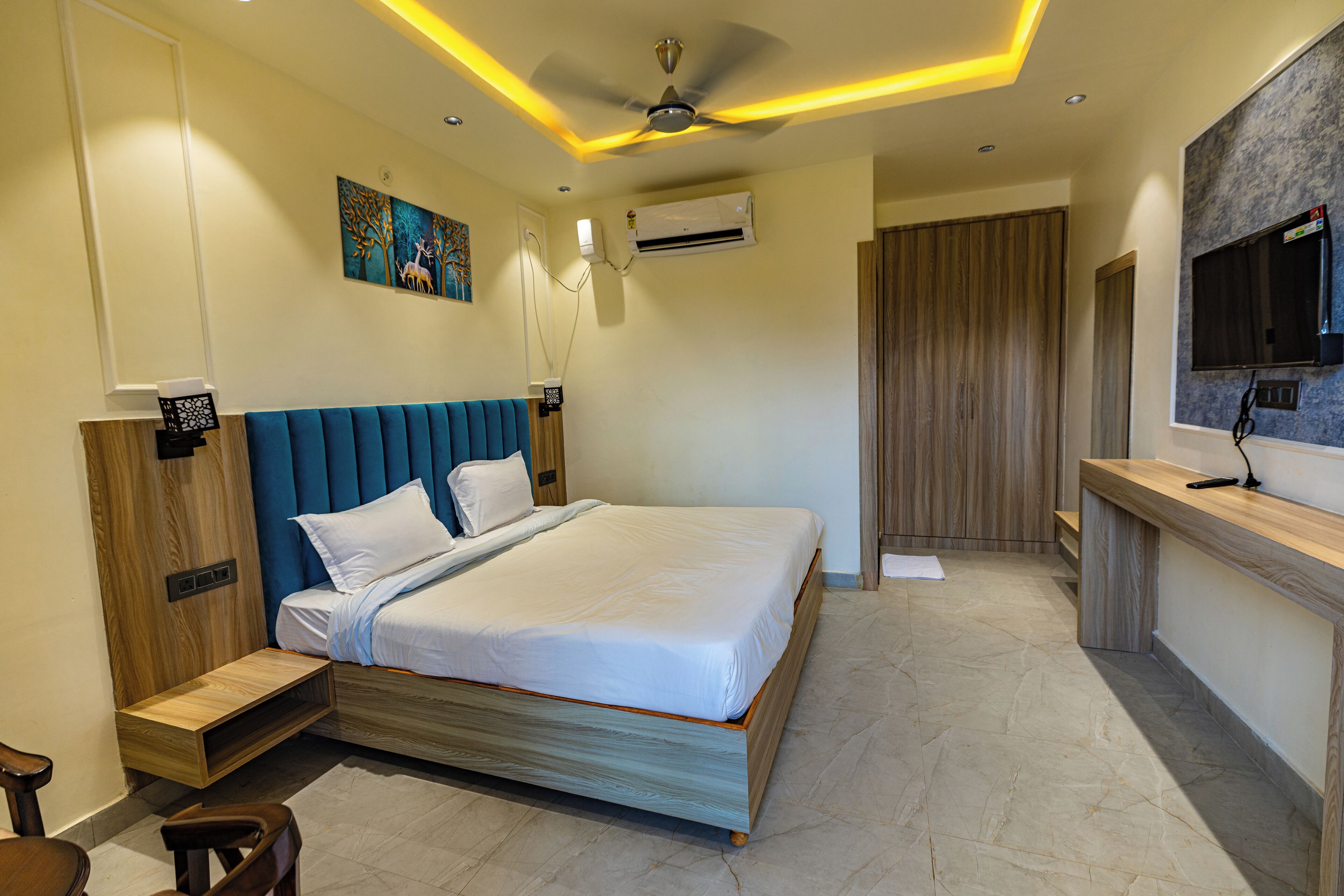 A modern hotel room with a large bed, a desk, and a television.