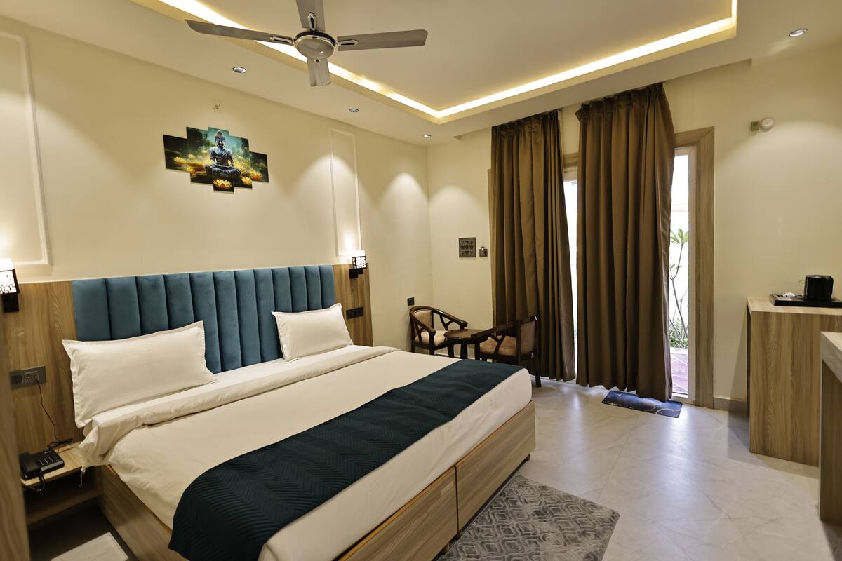 Une chambre d’hôtel équipée d’un lit, d’un bureau, d’une chaise et d’un ventilateur de plafond.