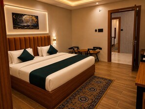 A hotel room with a large bed, a night sky artwork, a small table, and a chair. - Chandrika Greens Resort Near Prem Mandir (Vrindavan)