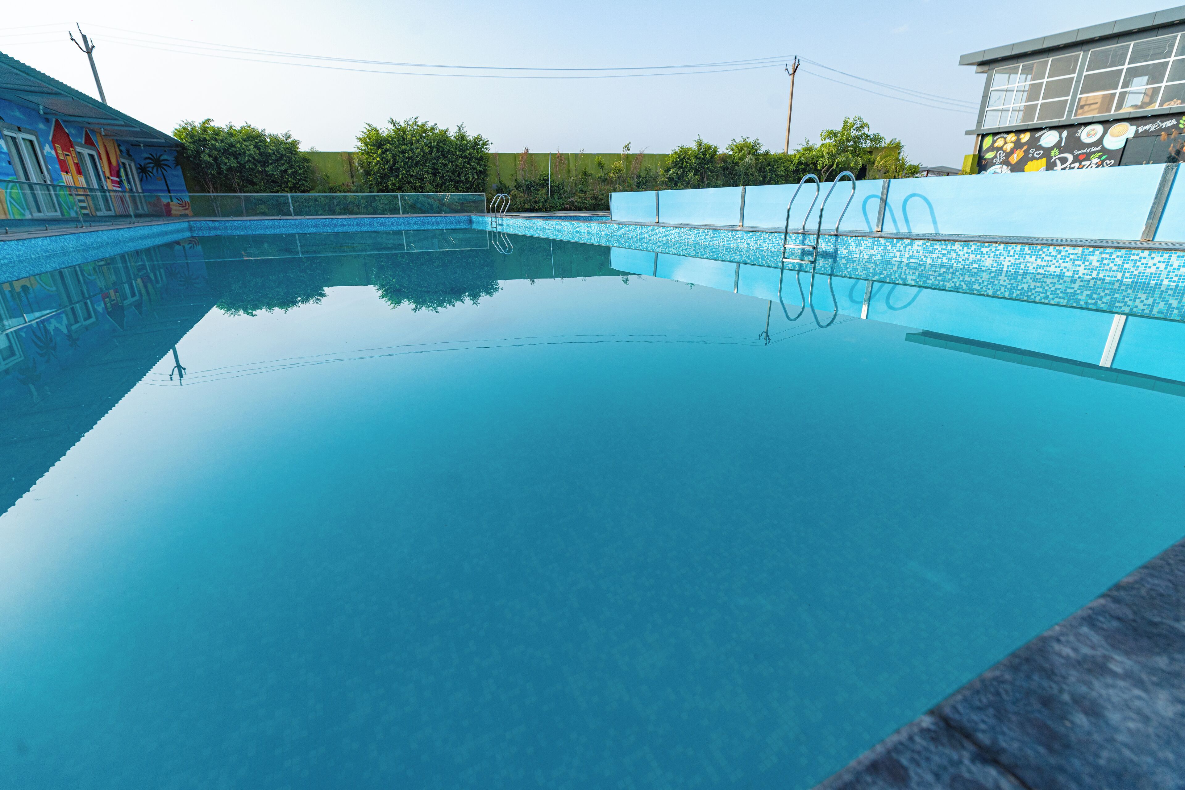 Una piscina limpida con borda piastrellata e scaletta.