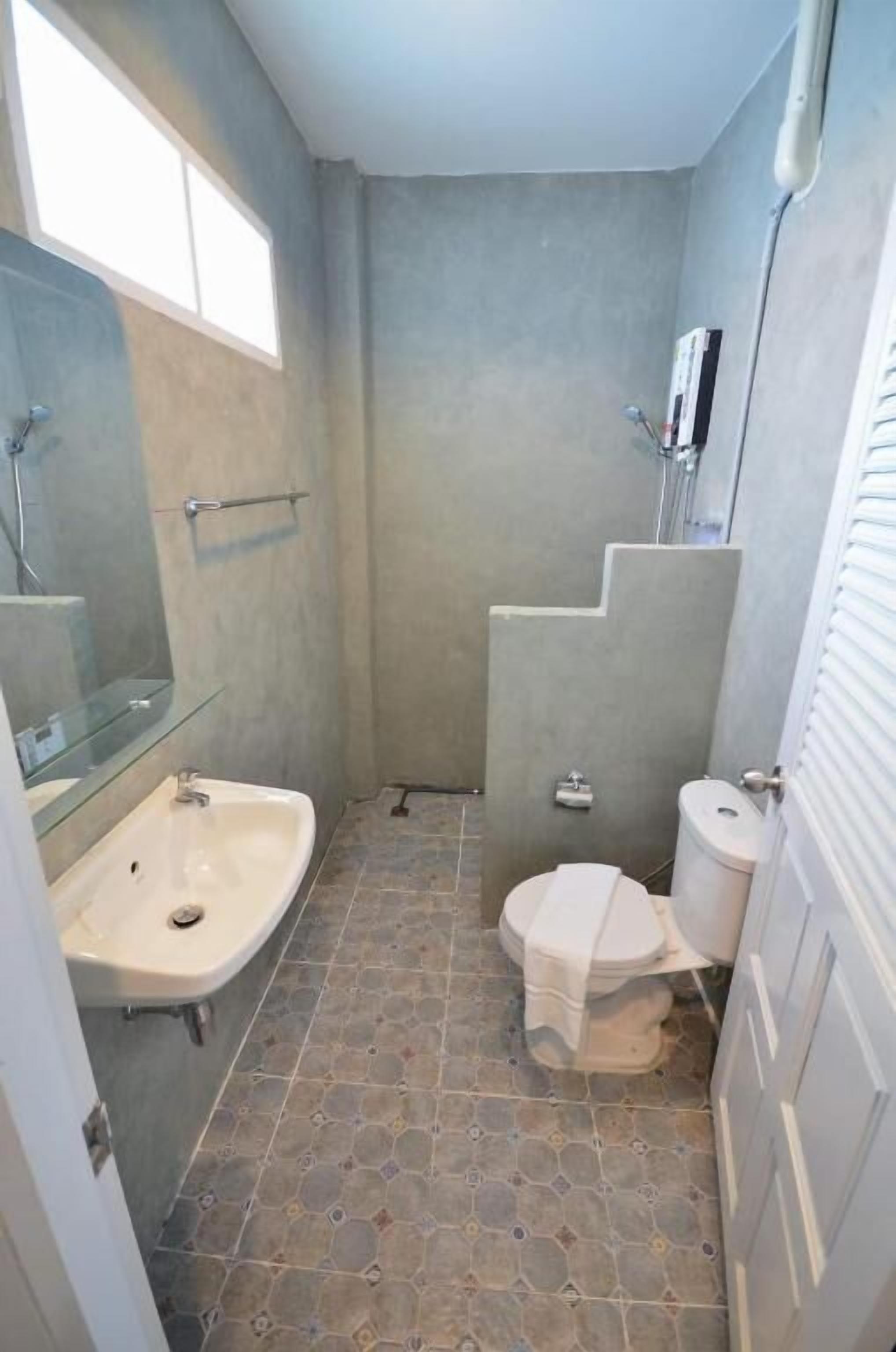 Un baño pequeño con lavabo, inodoro y zona de ducha.