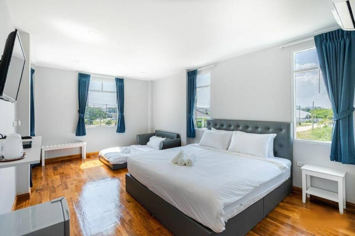 Une chambre d’hôtel moderne avec un grand lit, une table de chevet, un bureau avec une chaise et un téléviseur.