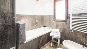 A modern bathroom with a large bathtub, a shower, and a toilet. - Hotel Vescovi (Asiago)
