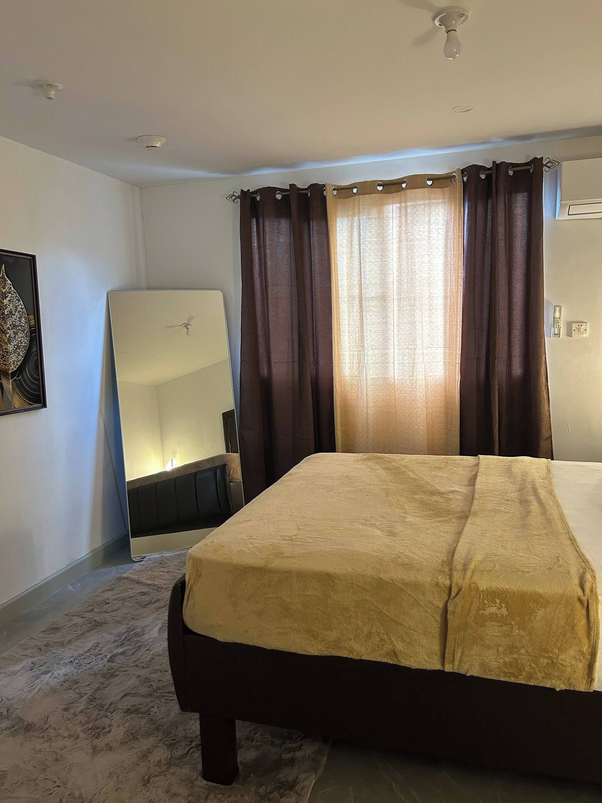 Ein Hotelzimmer mit einem Bett, einem großen Spiegel und einem Deckenventilator.