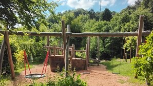 A playground with swings and a climbing structure.