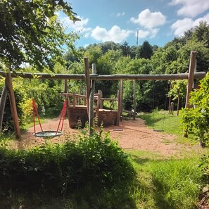 A playground with swings and a climbing structure. - Cozy attic apartment with 2 balconies and a stunning view (Betzenstein)