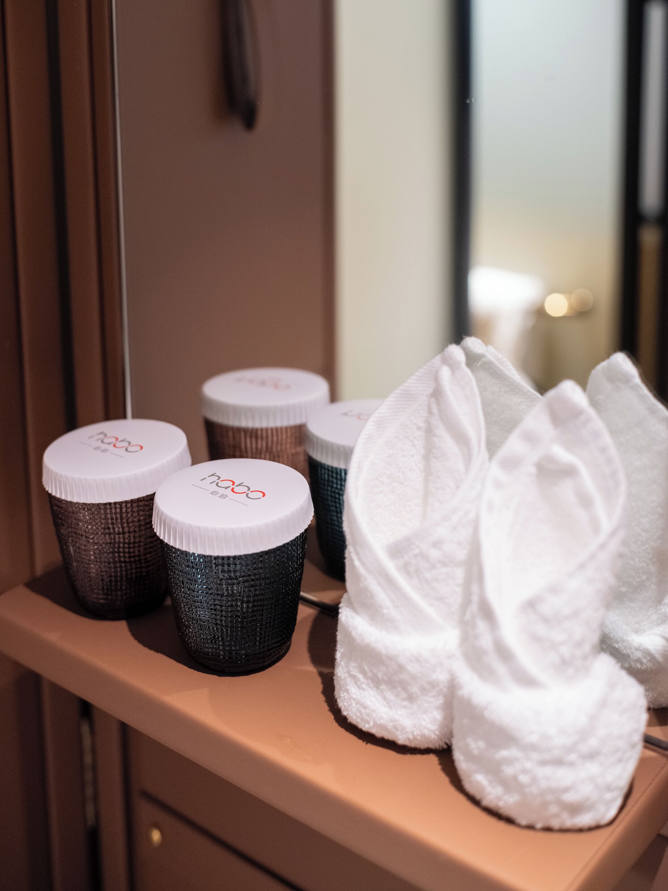 Un meuble-lavabo dans une salle de bain, avec des articles de toilette et des serviettes.