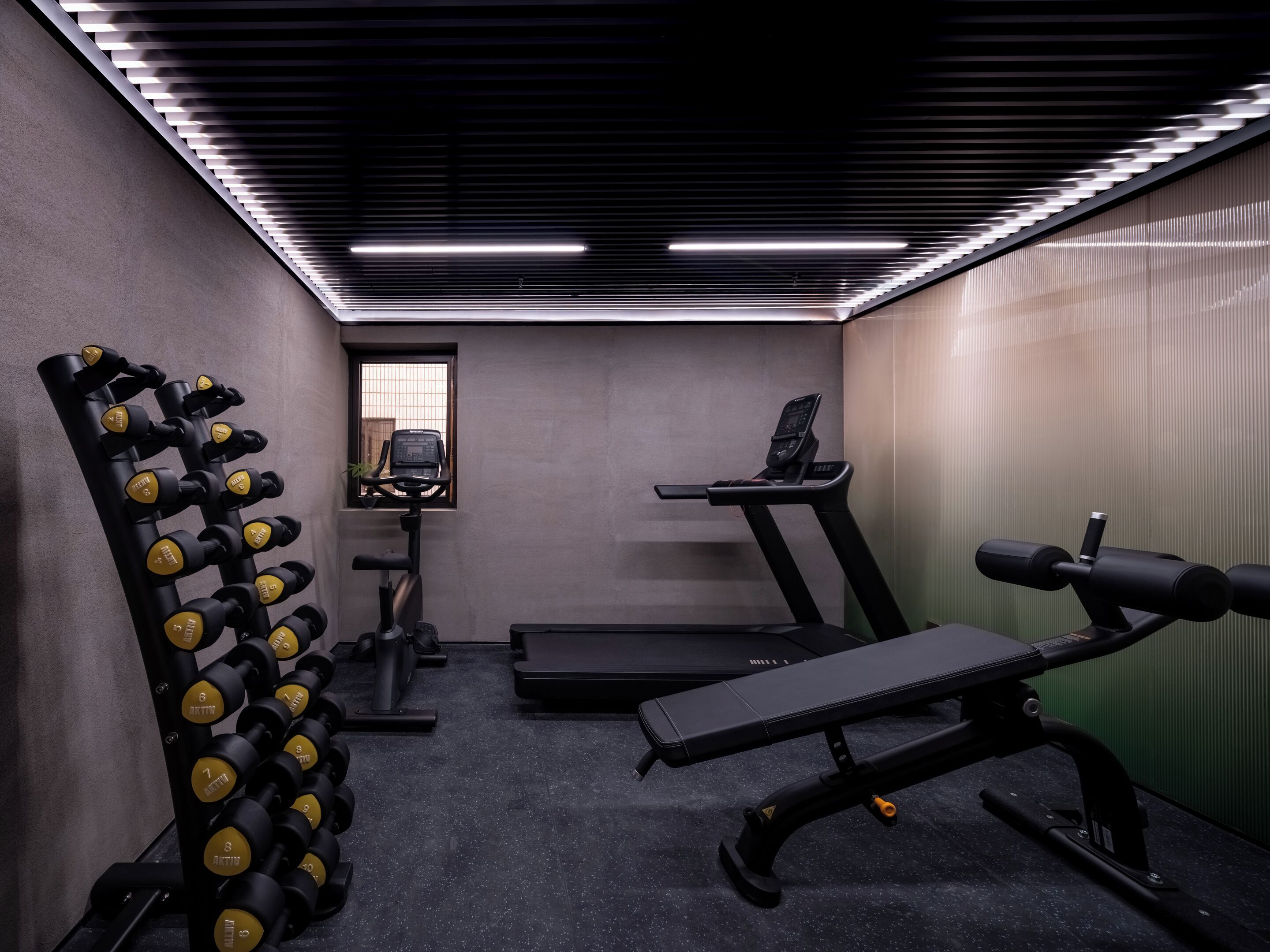 Ein Fitnessstudio mit Trainingsgeräten, Laufbändern und Kurzhanteln.