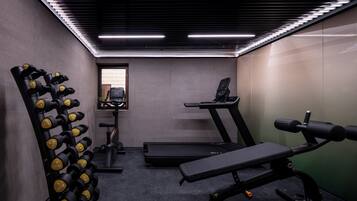 Ein Fitnessstudio mit Trainingsgeräten, Laufbändern und Kurzhanteln.