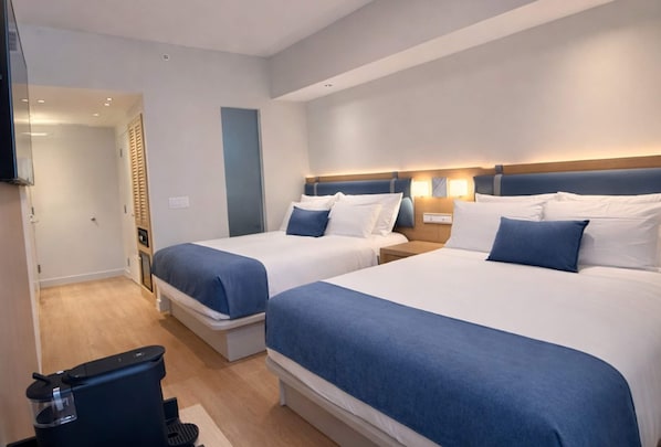 A hotel room with two beds, a TV, a desk, and a chair. - Dolce by Wyndham Miami Beach (Miami Beach)