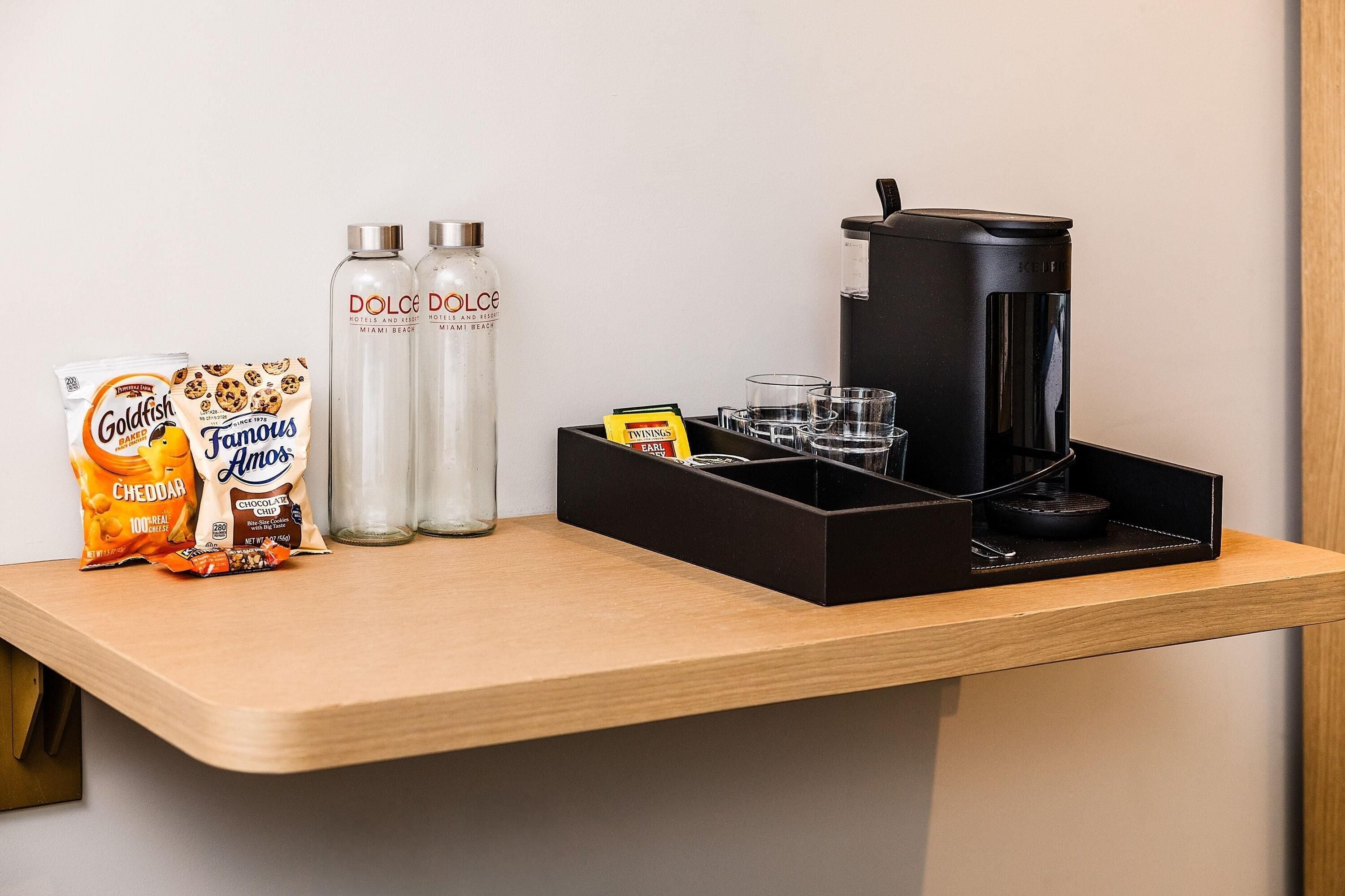 A breakfast bar with snacks, Dolce Dolce water bottles, and a coffee machine.