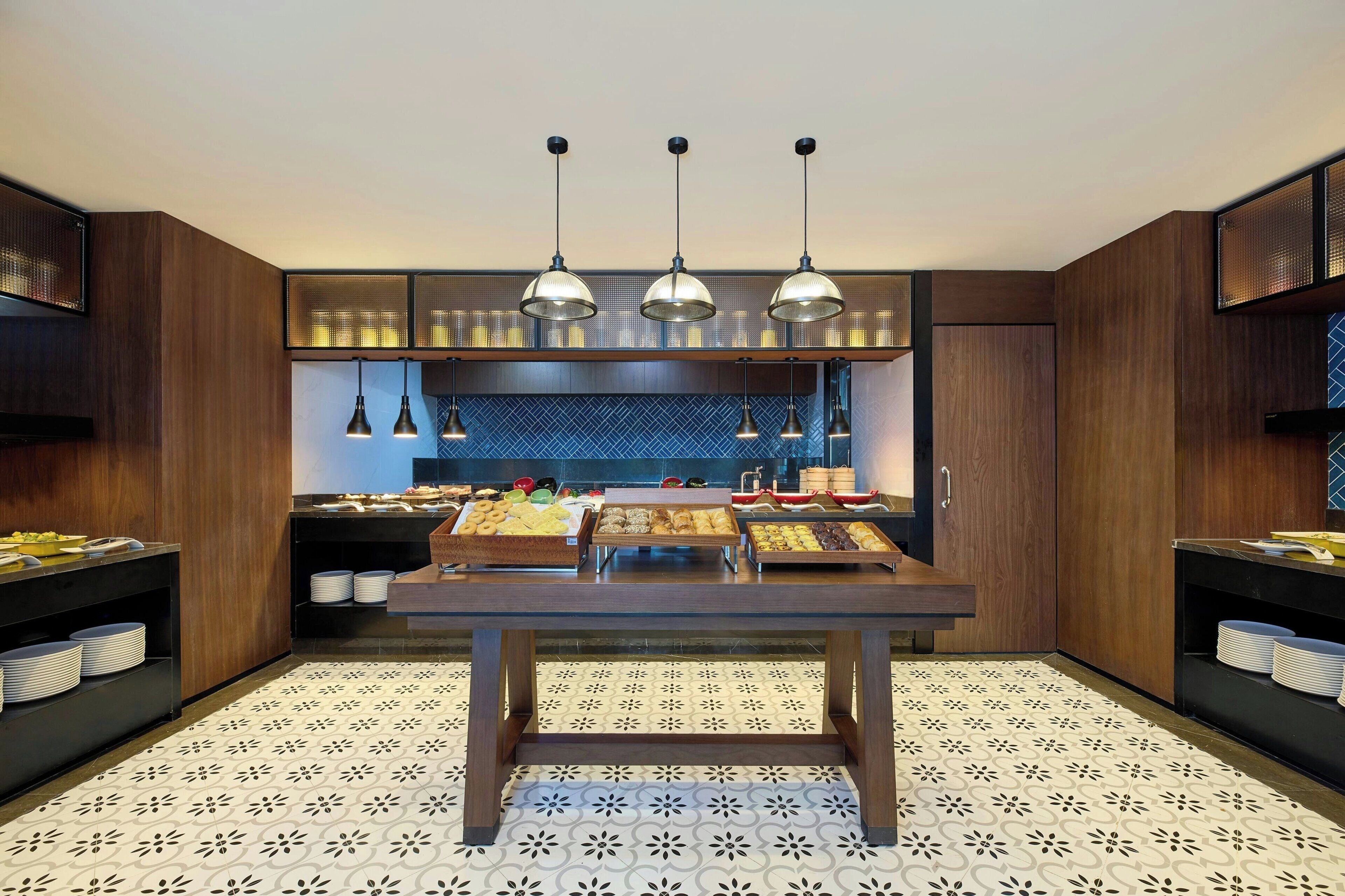 A modern kitchen with wooden cabinets, a central island, and hanging pendant lights.