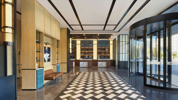 A modern lobby with a checkered floor, wooden paneling, and a glass entrance. - Four Points by Sheraton Kunming Chenggong (Kunming)
