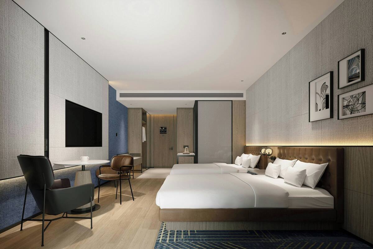 Une chambre d’hôtel moderne équipée d’un grand lit, d’un bureau, d’une chaise et d’un téléviseur.
