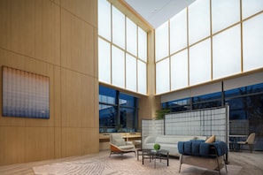 A spacious room with a large window, a sofa, a coffee table, and a chair. - Holiday Inn Express Suzhou SIP Suliu Road by IHG (Suzhou)