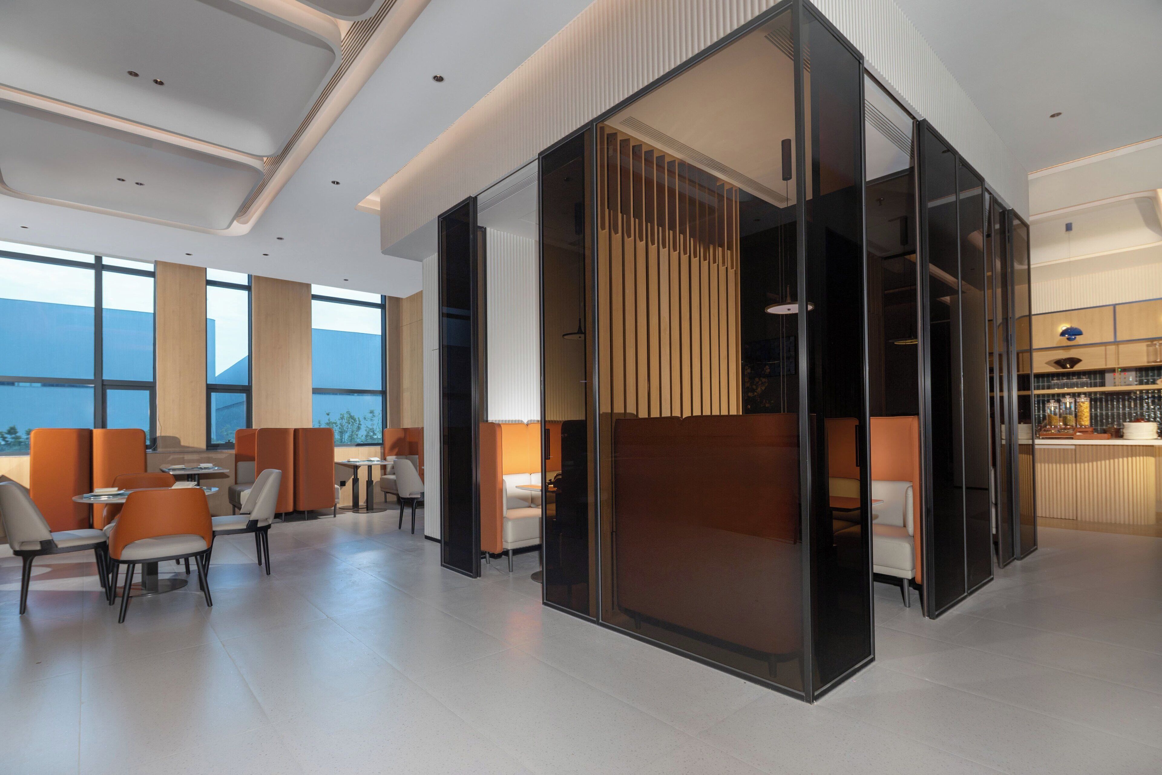 Un vestíbulo moderno de hotel con zonas de estar, un bar y grandes ventanales con vistas.