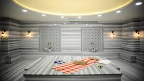 A modern spa room with a marble floor, a checkered towel, and two wall-mounted heaters.
