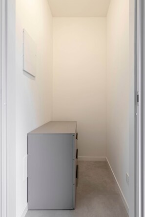 A narrow hallway with a grey cabinet against the wall. - Modern studio apartment air conditioning Bergamo center (Bergamo)