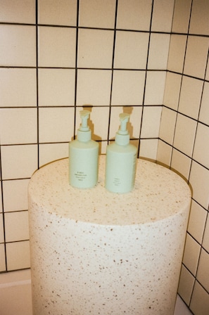 A bathroom with two hand soap dispensers on a speckled sink.