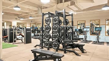 A gym with weightlifting equipment, treadmills, and exercise bikes.