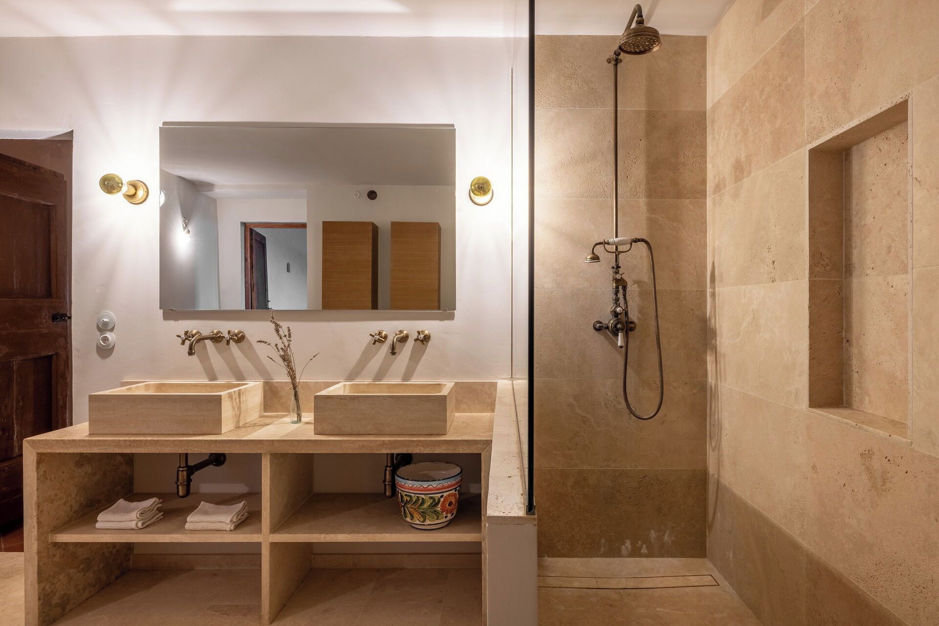 Une salle de bain avec deux lavabos, une douche et un miroir.
